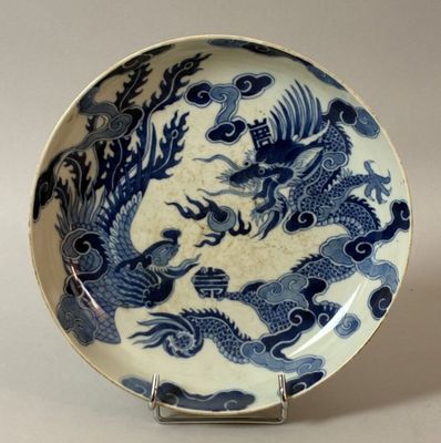 a blue and white plate with a dragon design on it