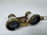 an old pair of binoculars sitting on top of a white table