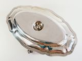 a silver object on a white surface with a small metal object in the middle of it