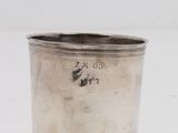 une coupe ancienne en argent munie d'une anse, sur fond blanc