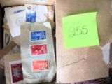 une boîte contenant de nombreux timbres et sur laquelle est collé un post-it