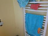 a towel rack in the corner of a bathroom with towels on it