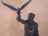 bronze statue of a man holding a bird in his hand