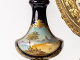 a clock that is sitting next to a vase on a table