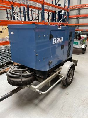 une photo d'une remorque transportant une machine bleue dans un entrepôt