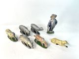 several figurines of animals and a man with a hat on
