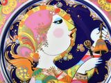 a plate with a picture of a woman holding a bell