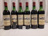 six bottles of red wine are lined up on a table
