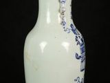 a white vase with blue designs on it on a black background