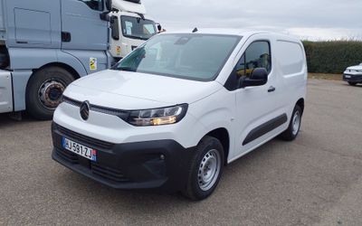 une camionnette blanche garée sur un parking à côté d'un camion bleu