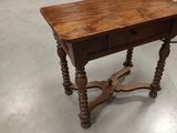 a wooden table with a drawer on it in a room