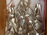 many forks and spoons in a box on the floor