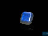 a close up of a glowing blue stone on a black surface