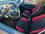 the interior of a car with red and black seats and a steering wheel
