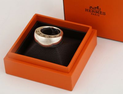 an orange box with a silver ring inside of it on a white surface