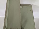 a small metal box with a door open on a white surface