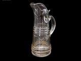 un pichet en verre transparent muni d'une anse, sur fond noir