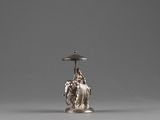 an image of a silver candle holder with a statue on it