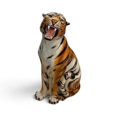 une figurine représentant un tigre assis sur une surface blanche