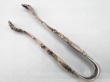a pair of silver tonges with handles and handles