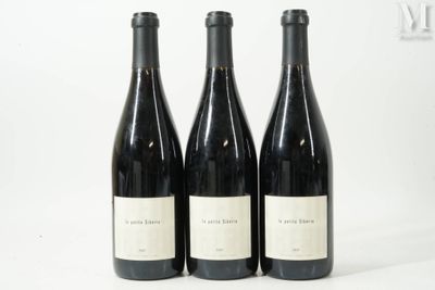 trois bouteilles de vin sont alignées sur une surface blanche