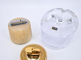 un petit objet en verre posé sur un socle en bois, à côté d'un autre petit objet en verre