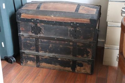 an old wooden chest sitting on the floor next to a dresser