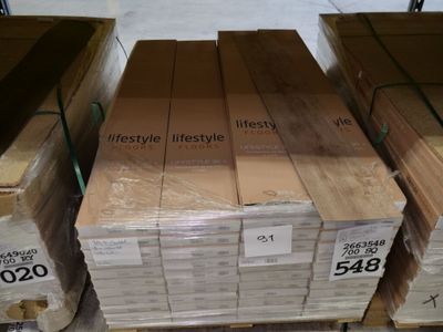 Plusieurs caisses en bois sont empilées sur une palette dans un magasin