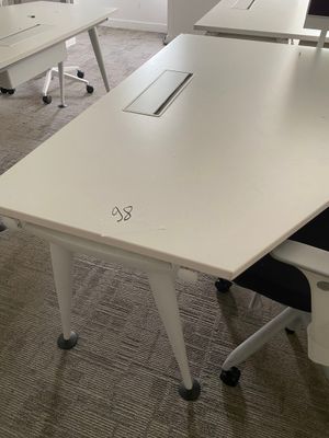 a white table with a laptop on it in a room