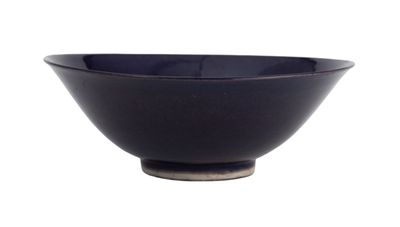 un bol noir posé sur une surface blanche