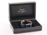 a black box with a watch inside of it on a white surface