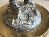 a bronze statue of a man with a dog on a plate