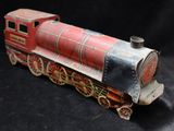 a red and black toy train sitting on a black surface