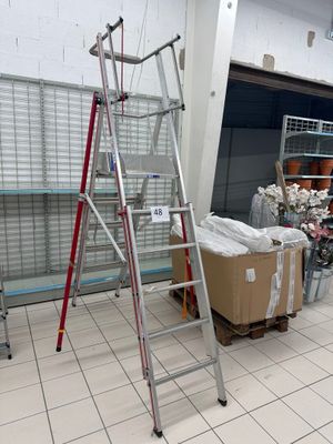 une échelle posée dans une pièce, à côté de quelques cartons