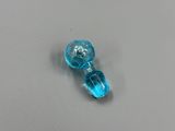 un petit objet en verre bleu posé sur une surface grise