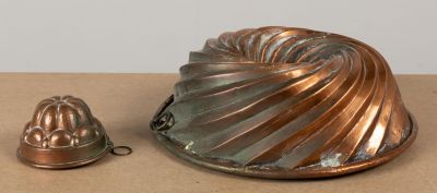 un moule à gâteau en métal et un moule en métal posés sur une table