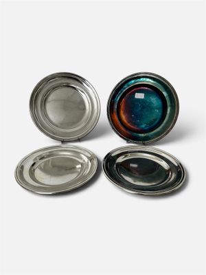 trois plats en verre argenté et bleu posés sur une surface blanche