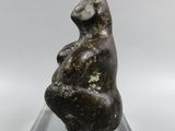 sculpture of a woman sitting on a rock on a clear base