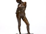 bronze statue of a man standing on a base with his hands in his pockets