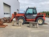 une photo d'un tracteur rouge garé devant un bâtiment