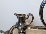 a silver tray with a silver pitcher on top of it