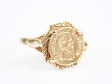 Gros plan sur une bague en or ornée d'une pièce de monnaie