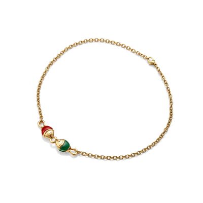 a gold bracelet with a green, red and white bead
