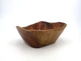a wooden bowl that is sitting on a white surface
