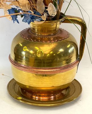 un vase en or contenant des fleurs bleues, posé sur une assiette