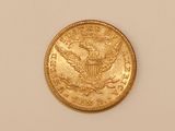 a close up of a gold coin on a white surface