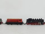 several toy trains are lined up in a row on a white surface