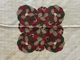 a red, green, and white placemat on a white table