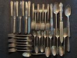 un grand nombre de cuillères et de fourchettes disposées sur une table