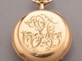 une image représentant une montre de poche en or ornée d'un monogramme